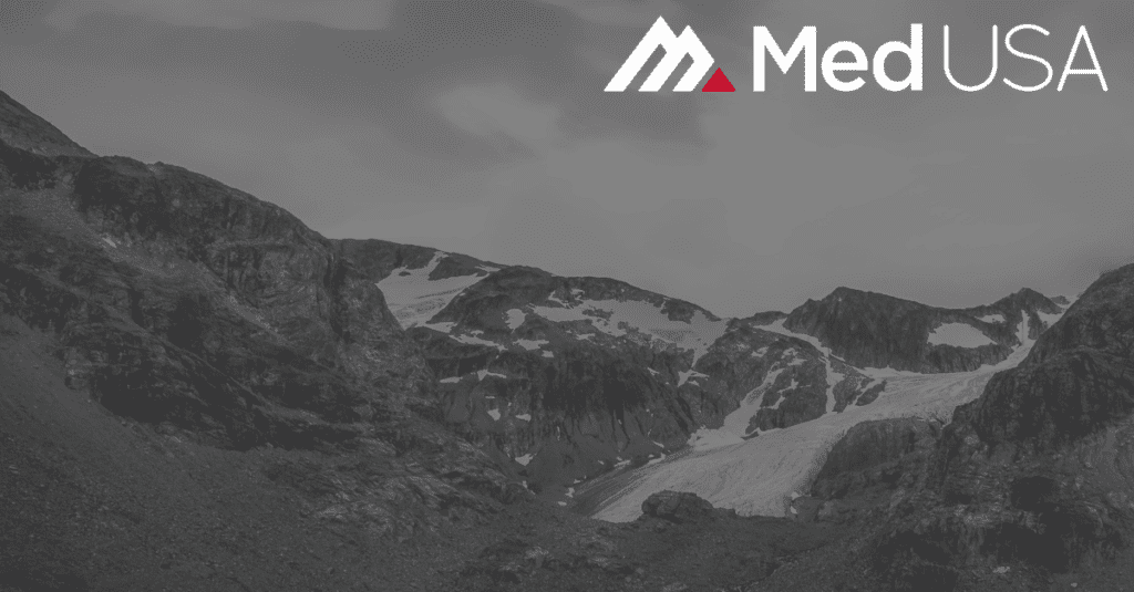 faded black and white image of mountain valley with red and white med usa logo