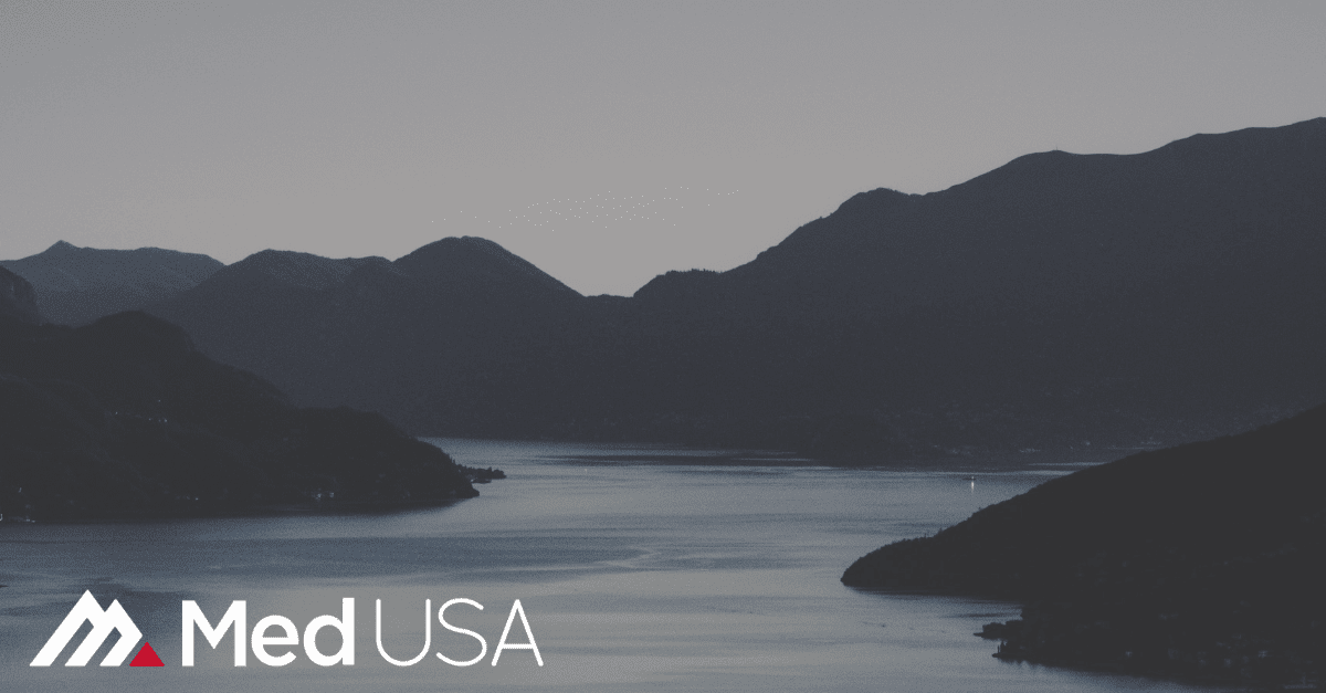 black and white image of lake and hills and white and red med usa logo for healthcare compliance