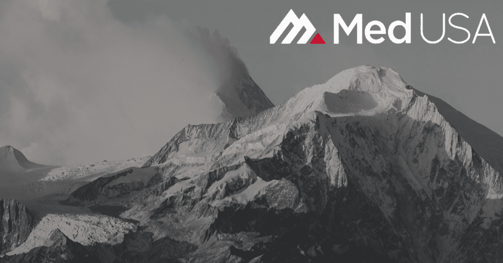 black and white photo of mountain top with snow with white and red med usa logo