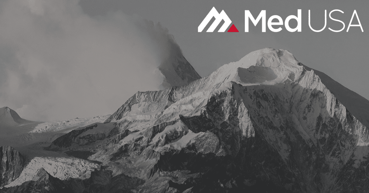 black and white photo of mountain top with snow with white and red med usa logo