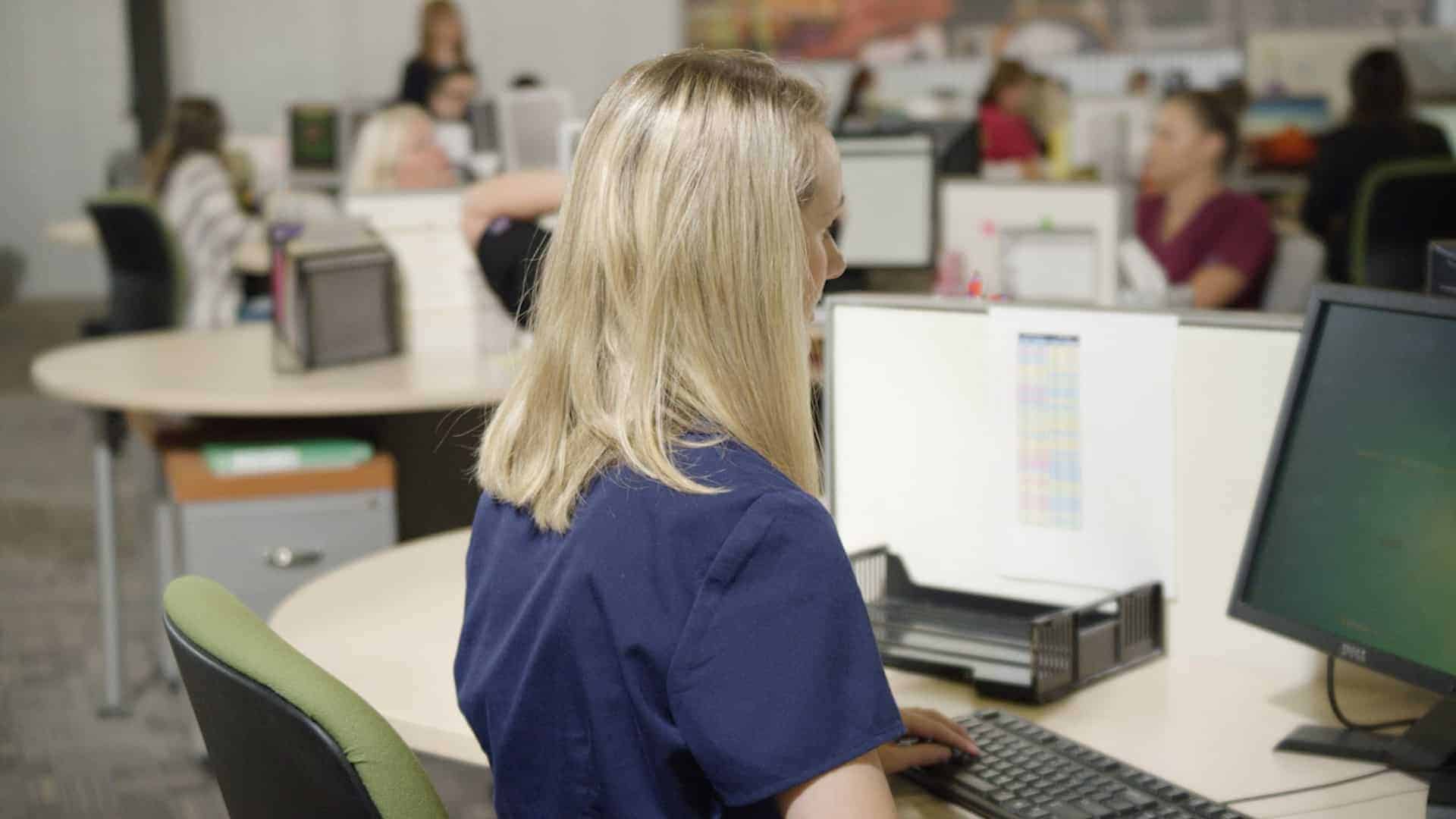 image of blonde woman at computer looking at rcm services from Med USA