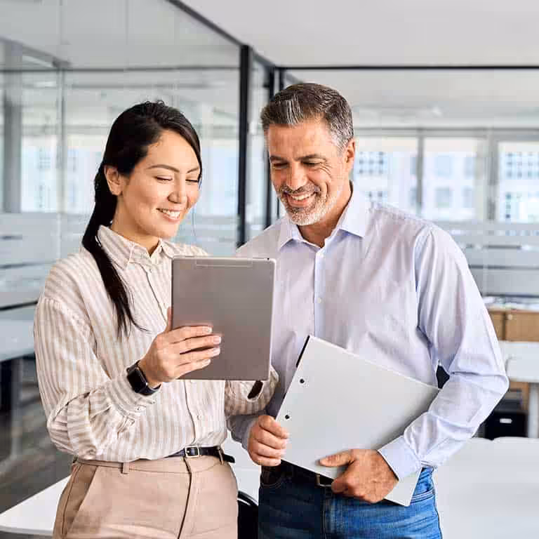 Smiling coworkers using tablet device