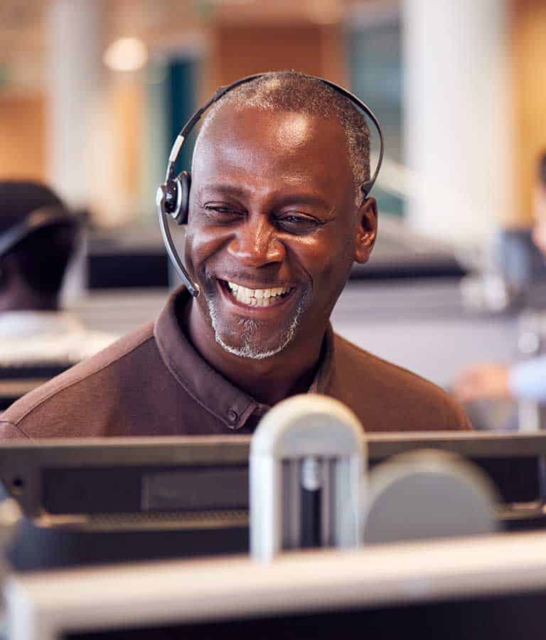 Smiling man with headset at the workplace