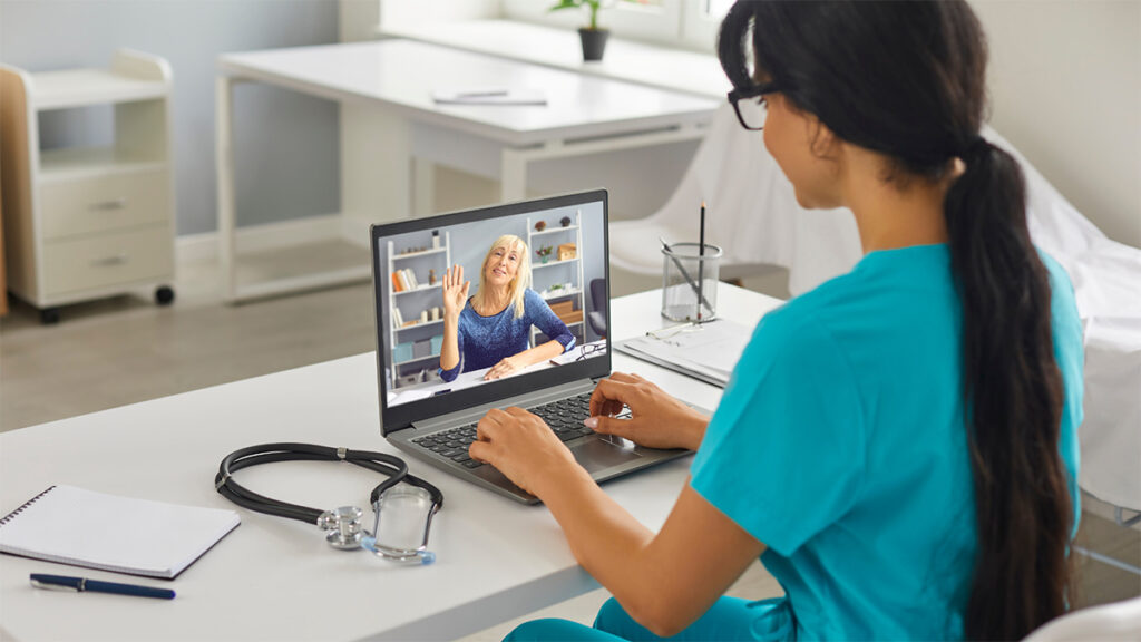 A telehealth provider working with a patient on a laptop