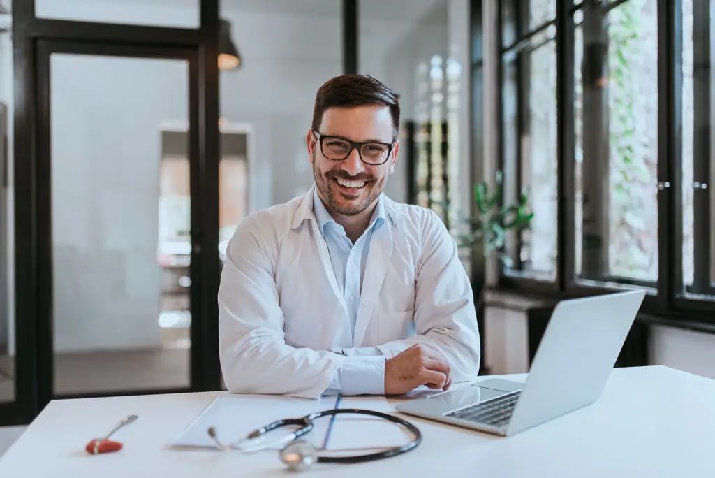 Orthopedic doctor sitting at desk smiling