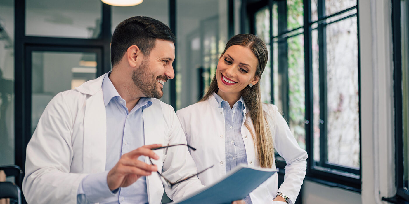 Two healthcare professionals having a discussion while looking at a clipboard