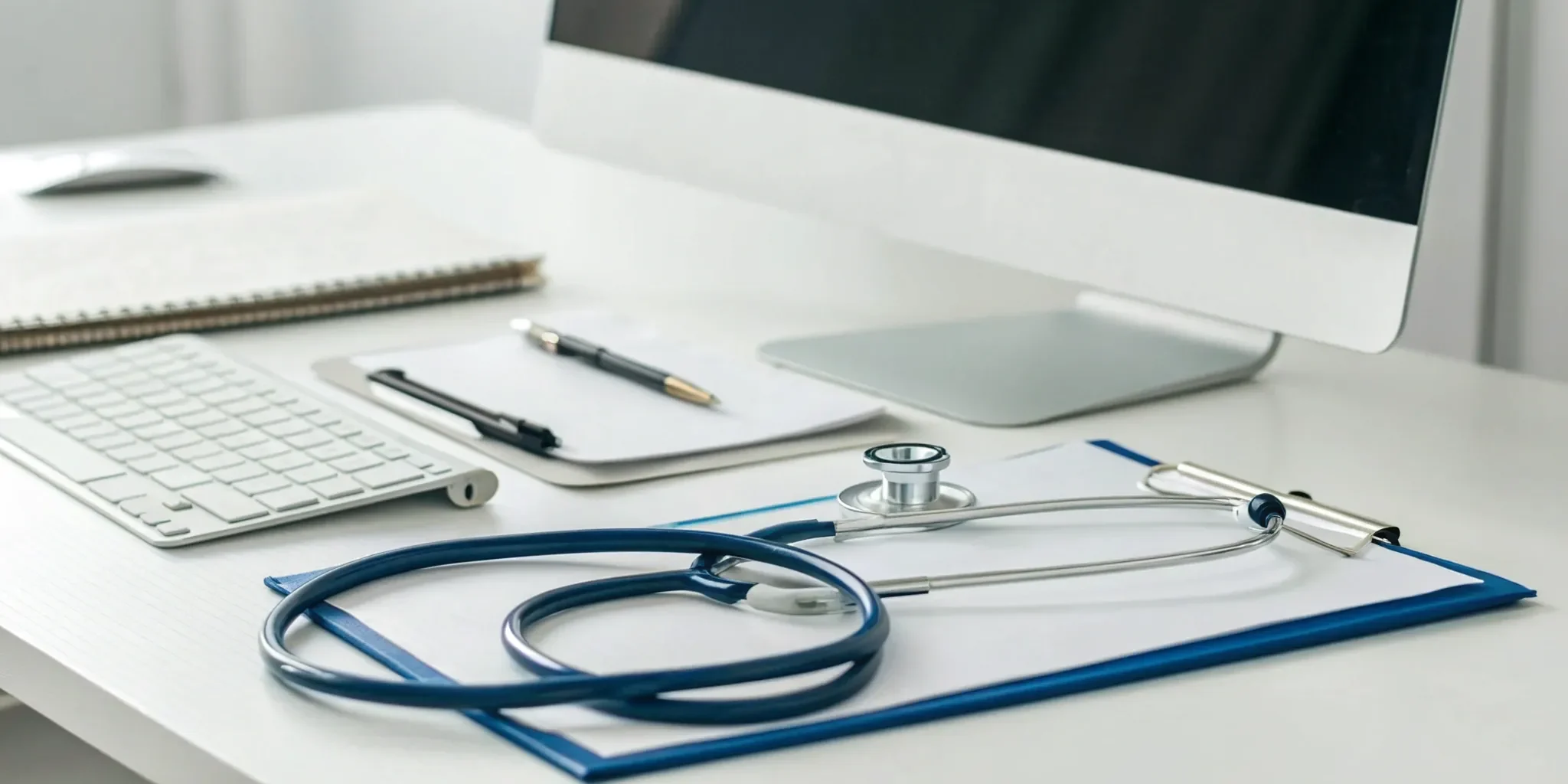 A medical desk with a computer and clipboard for managing the lab billing process.