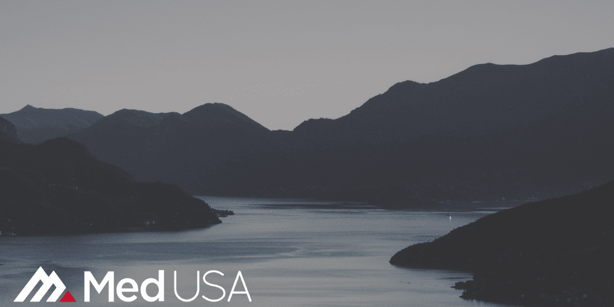 black and white image of lake and hills and white and red med usa logo for healthcare compliance