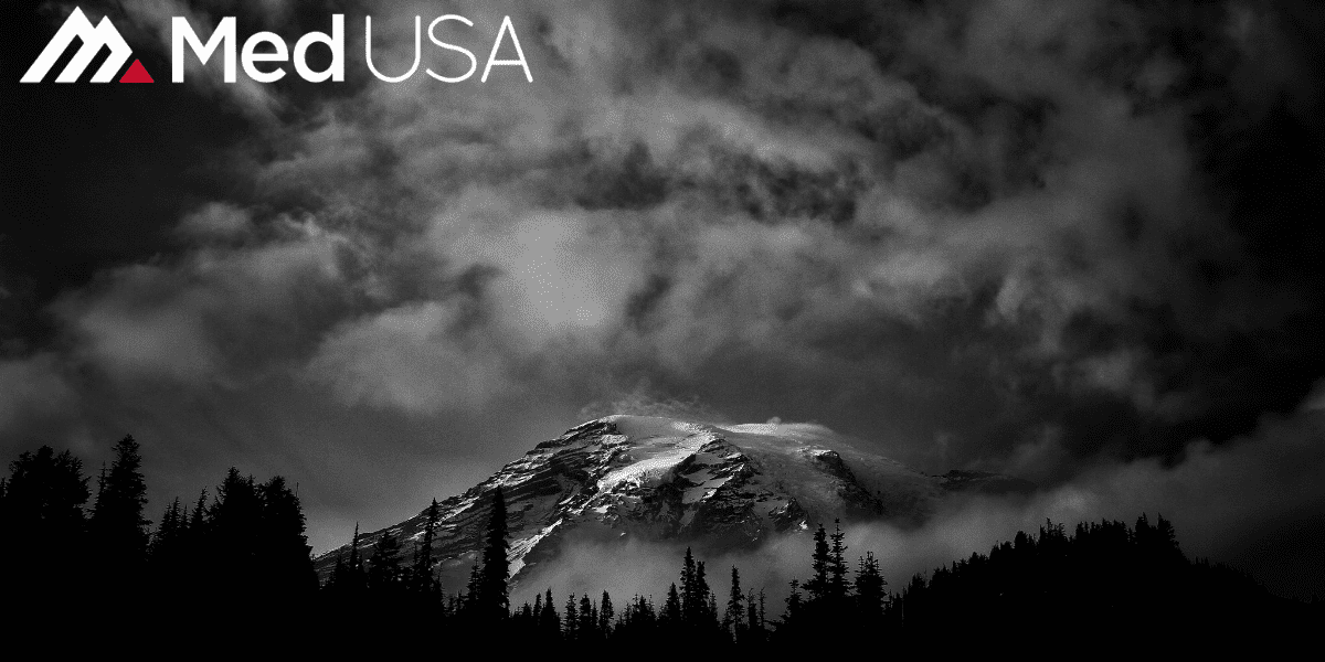 black and white image of forest and mountain with white and red Med USA logo