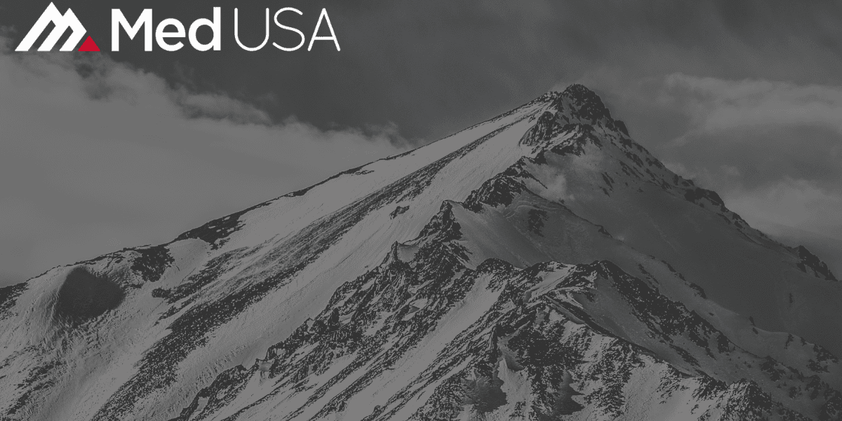 faded black and white image of mountain peak with white and red Med USA logo