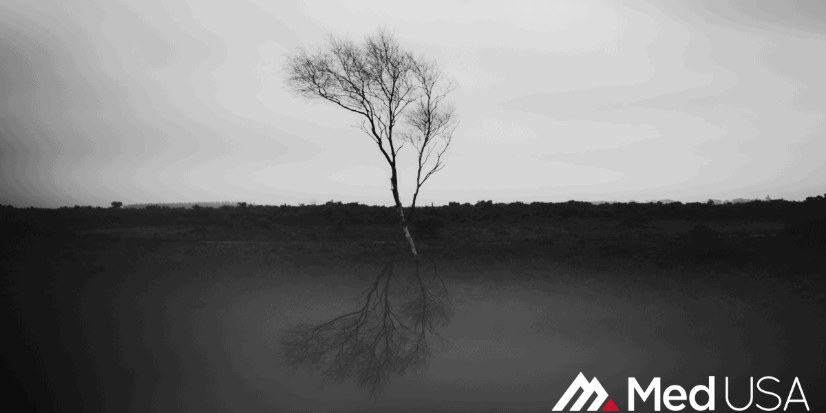 black and white image of a tree in the desert with white and red med usa logo