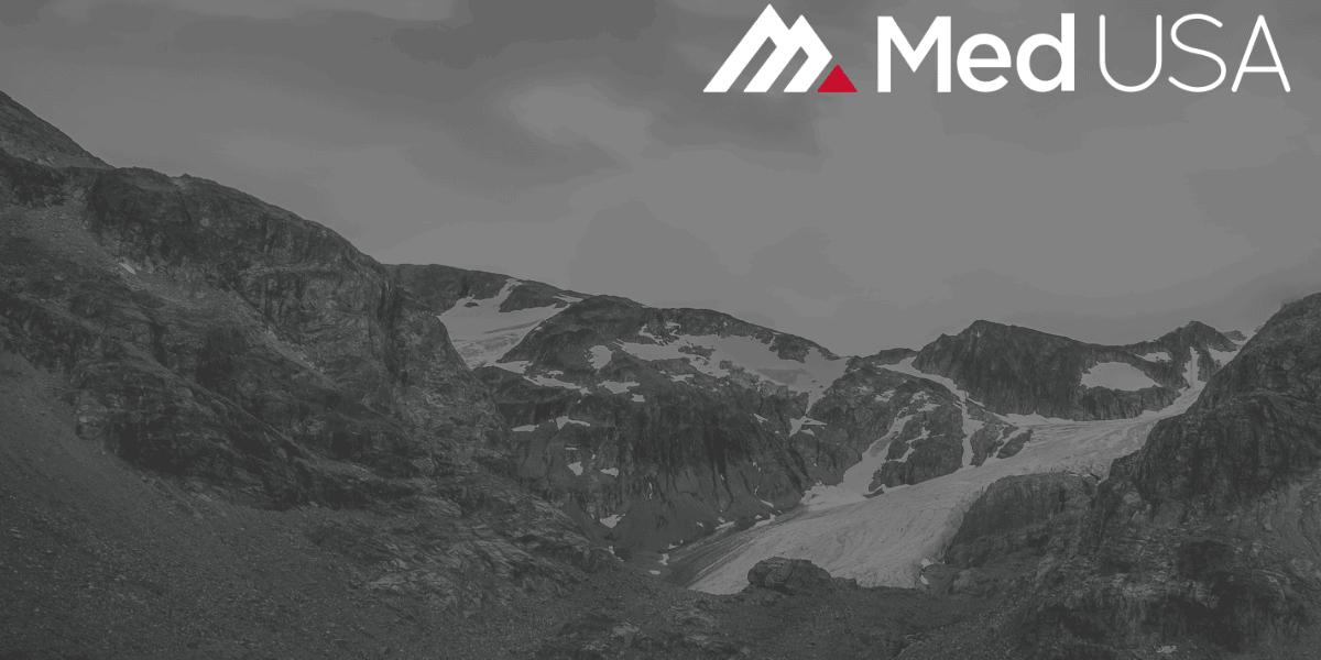 faded black and white image of mountain valley with red and white med usa logo