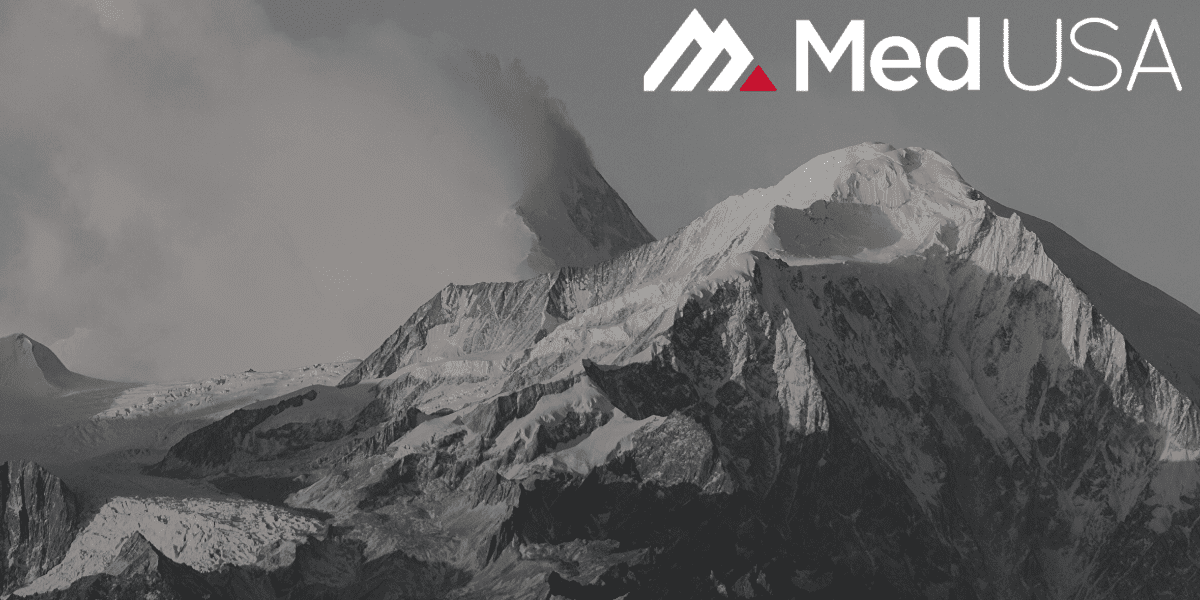 black and white photo of mountain top with snow with white and red med usa logo