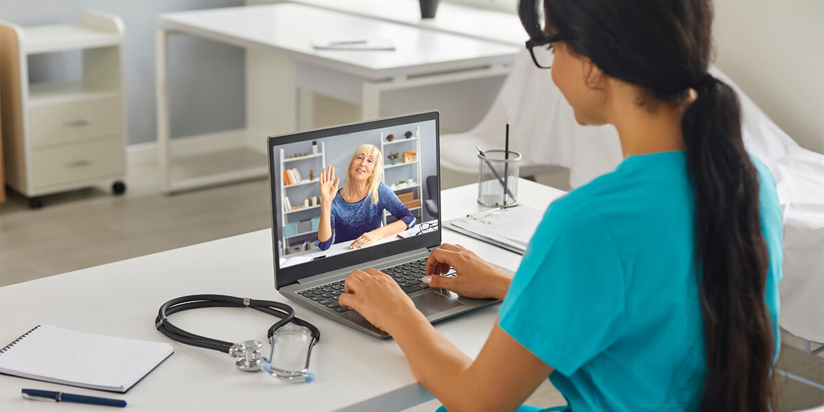 A telehealth provider working with a patient on a laptop